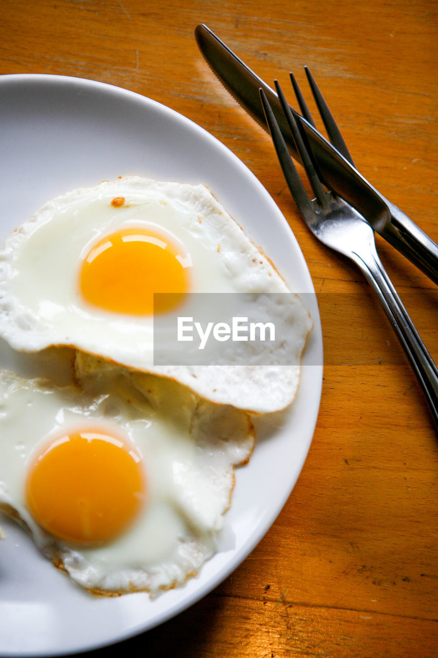 High angle view of fried eggs in plate on table