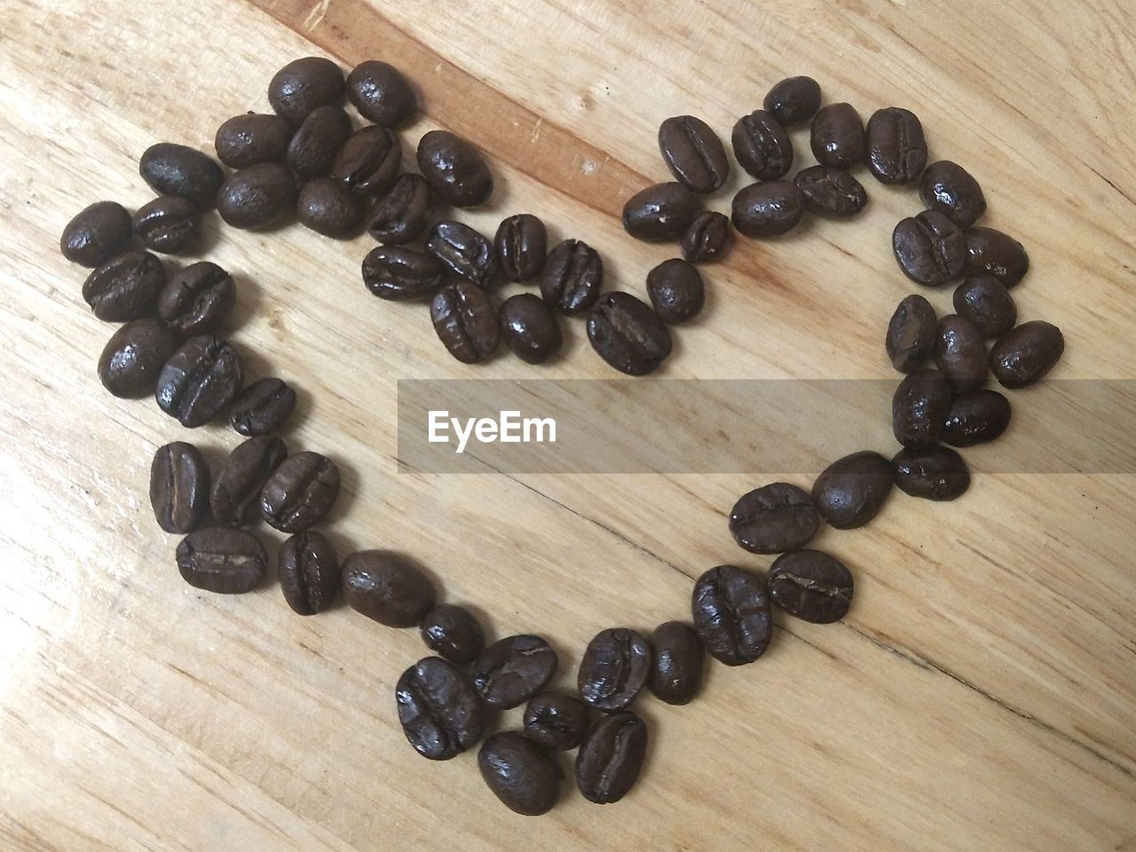 HIGH ANGLE VIEW OF COFFEE BEANS ON WOODEN TABLE