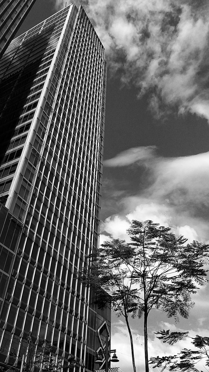 Low angle view of modern building against cloudy sky