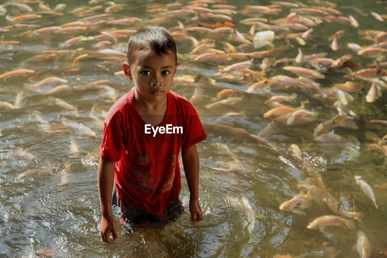 PORTRAIT OF BOY SWIMMING IN WATER AT PARK