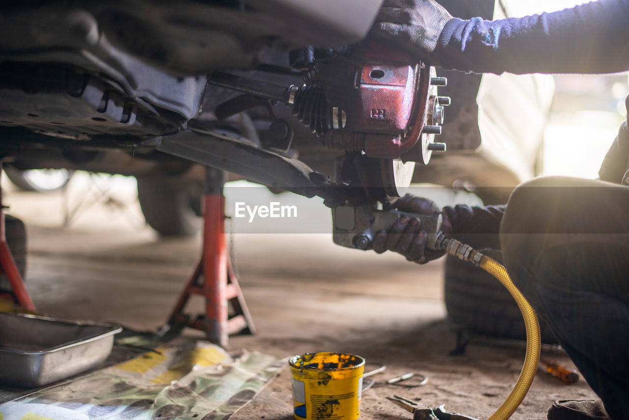 cropped image of man repairing car engine