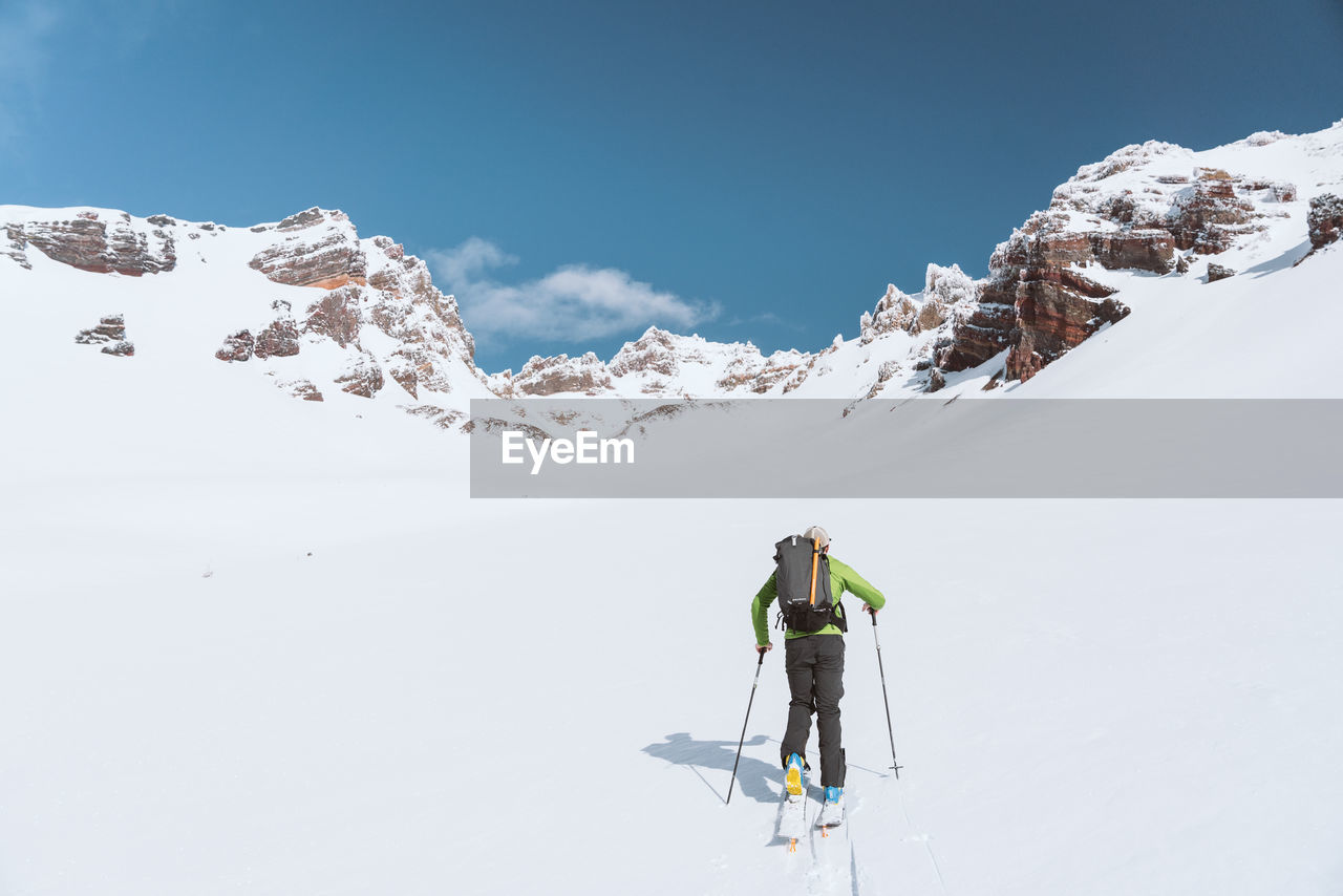 Athlete skinning towards mountains during sunny day