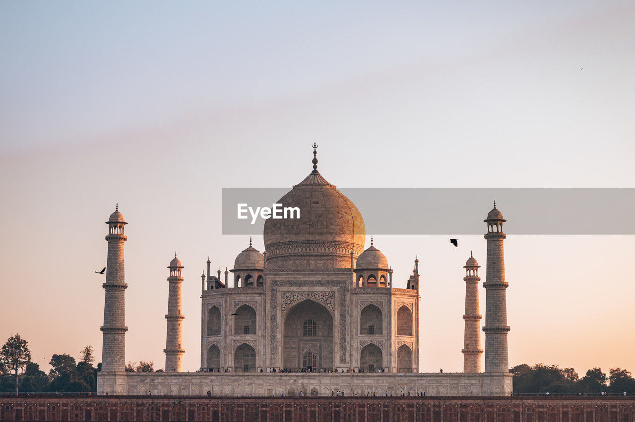 architecture, travel destinations, religion, dome, place of worship, built structure, landmark, travel, building exterior, building, sky, tourism, history, nature, marble, the past, sunset, city, ancient, arch, calligraphy, brick, tower, clear sky, outdoors, temple, water, memorial, monument, tomb, beauty in nature