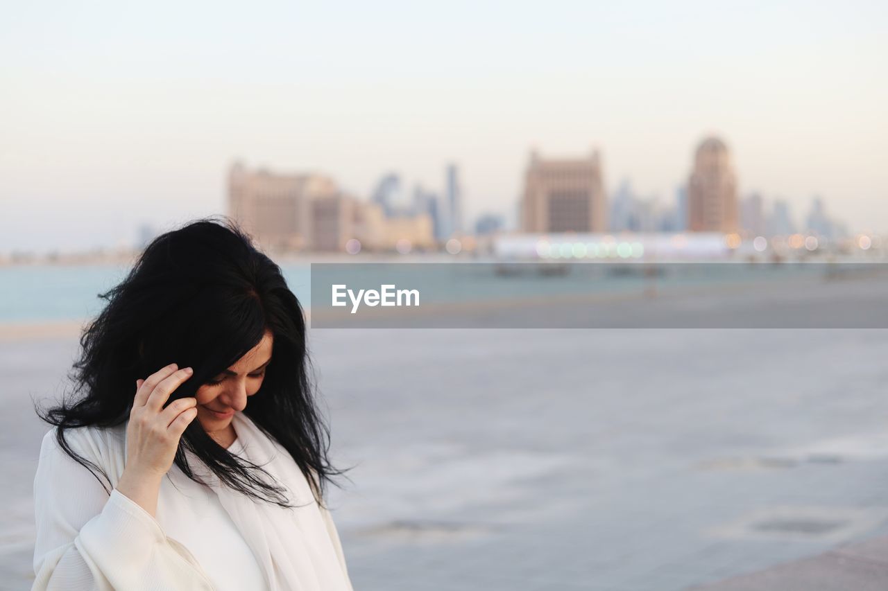 Side view of young woman looking away at beach