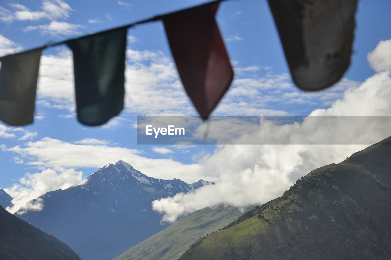 Colorful tibetan flags with script with the background of mountains and clouds