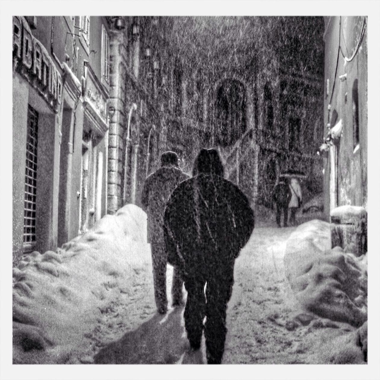 People walking in street while snowing