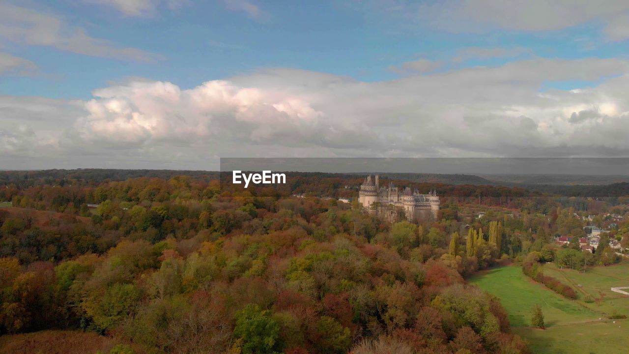 HIGH ANGLE VIEW OF TREES AND BUILDINGS IN CITY AGAINST SKY