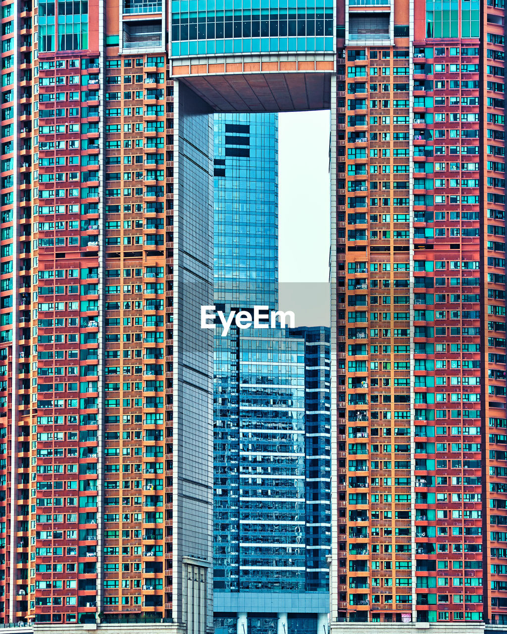 LOW ANGLE VIEW OF MODERN GLASS BUILDING IN CITY