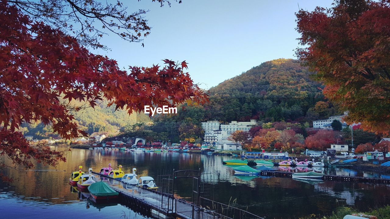 BOATS MOORED IN LAKE AGAINST SKY DURING AUTUMN