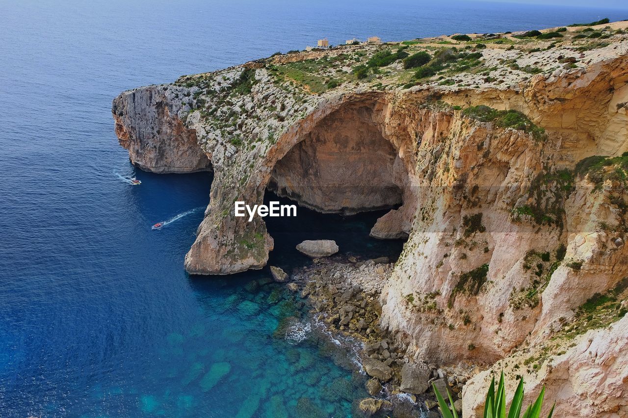 Rock formation in sea against sky