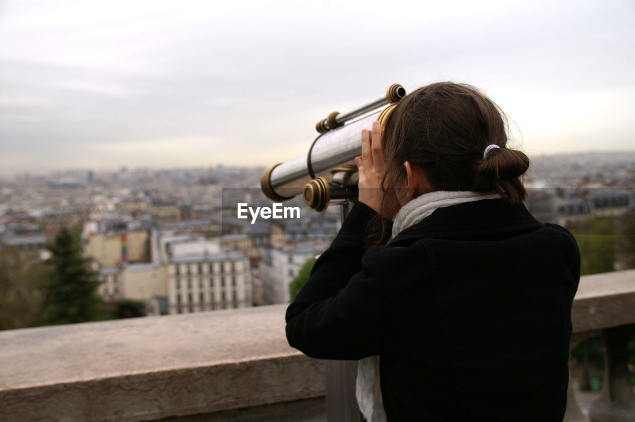 Woman photographing through camera in city