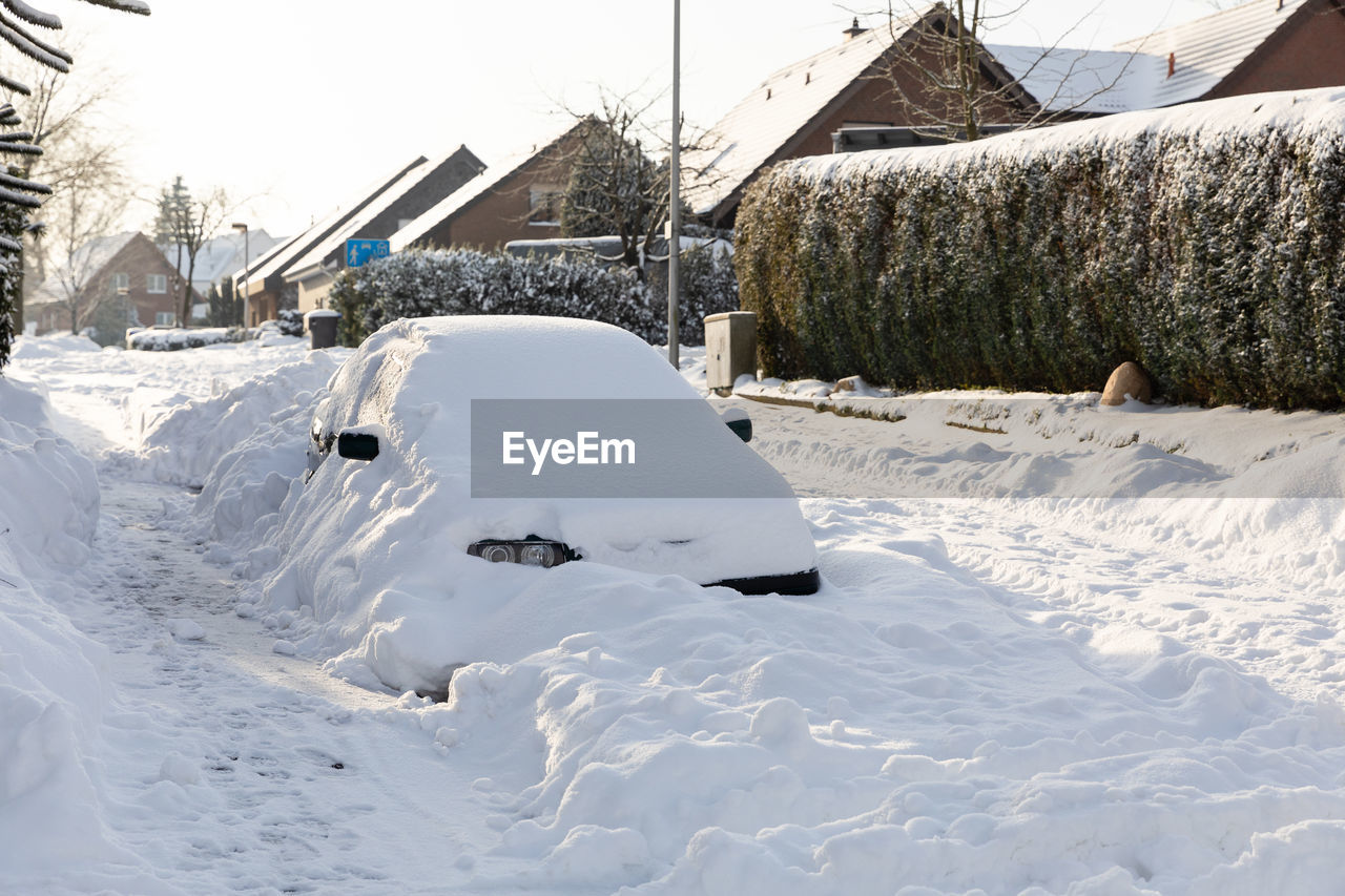 SNOW COVERED FIELD BY BUILDINGS