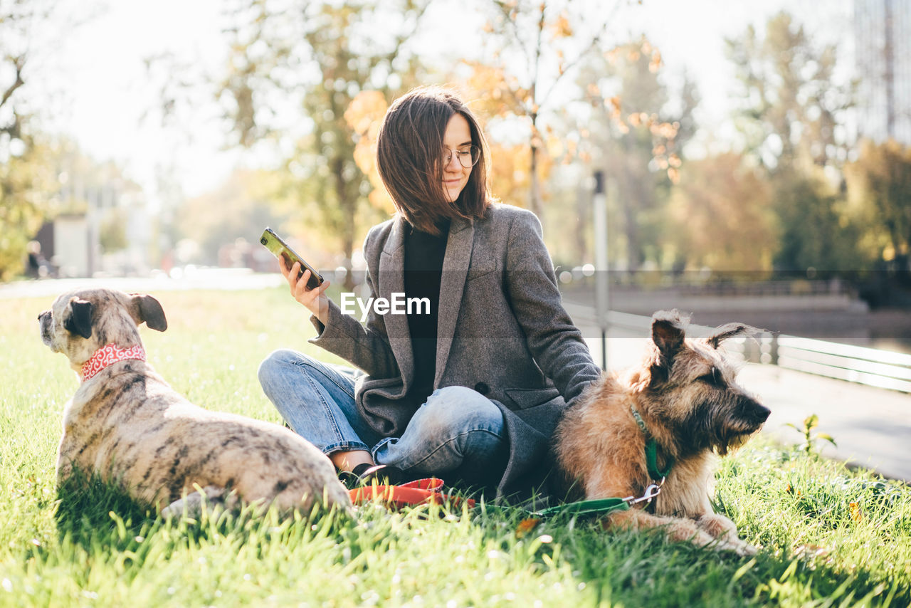 rear view of woman with dog on grassy field