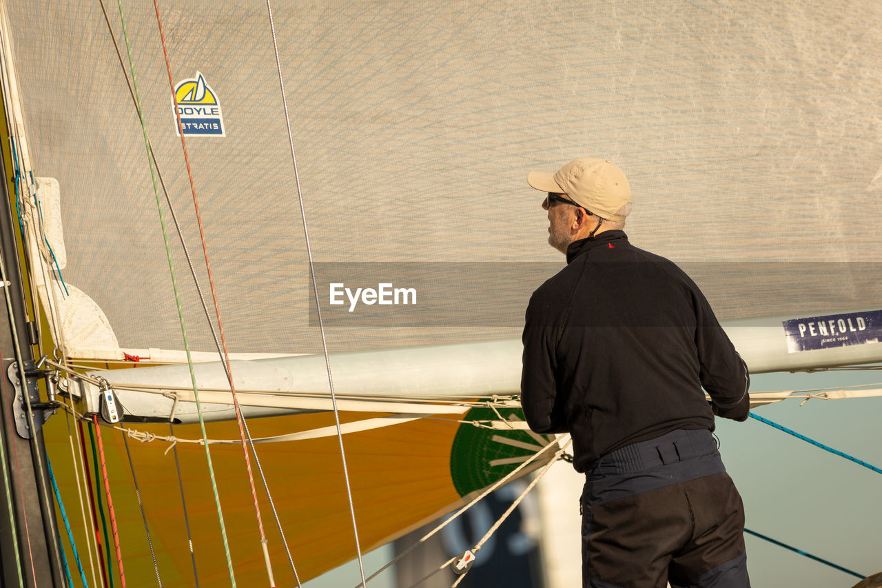 MAN STANDING ON BOAT IN SEA