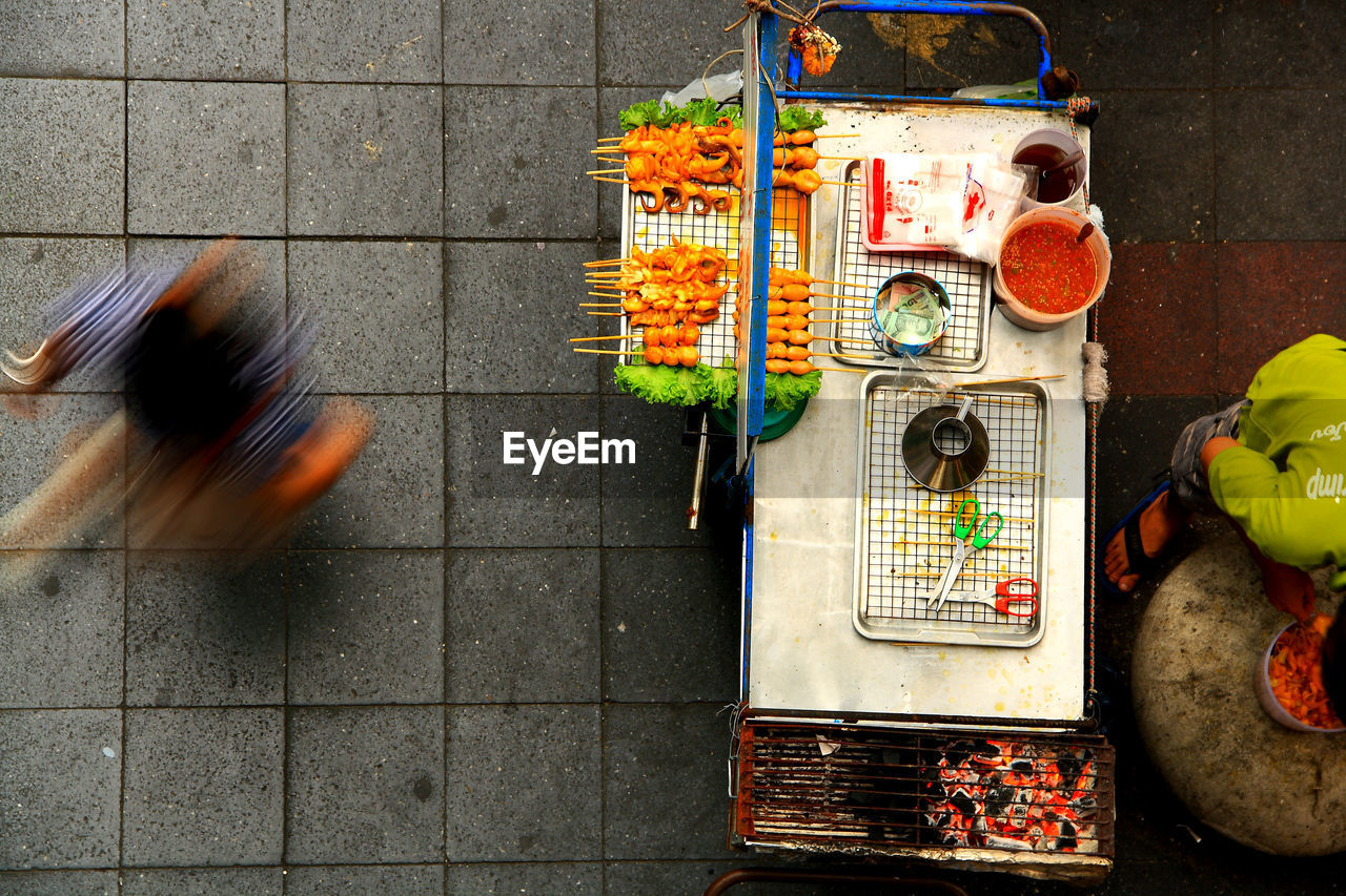 Directly above shot of vendor at market stall by footpath