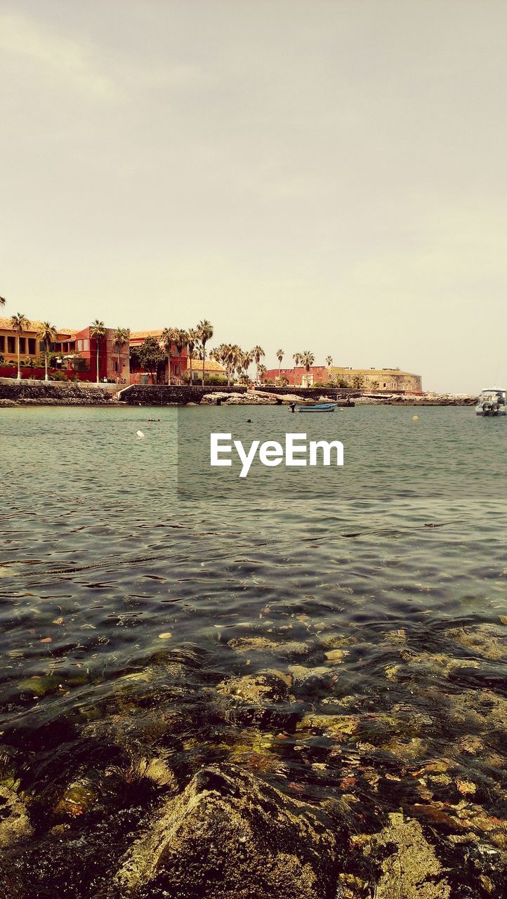 Scenic view of sea by city against sky
