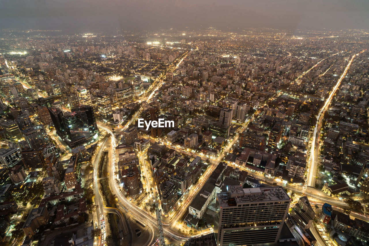 High angle view of illuminated cityscape against sky at night