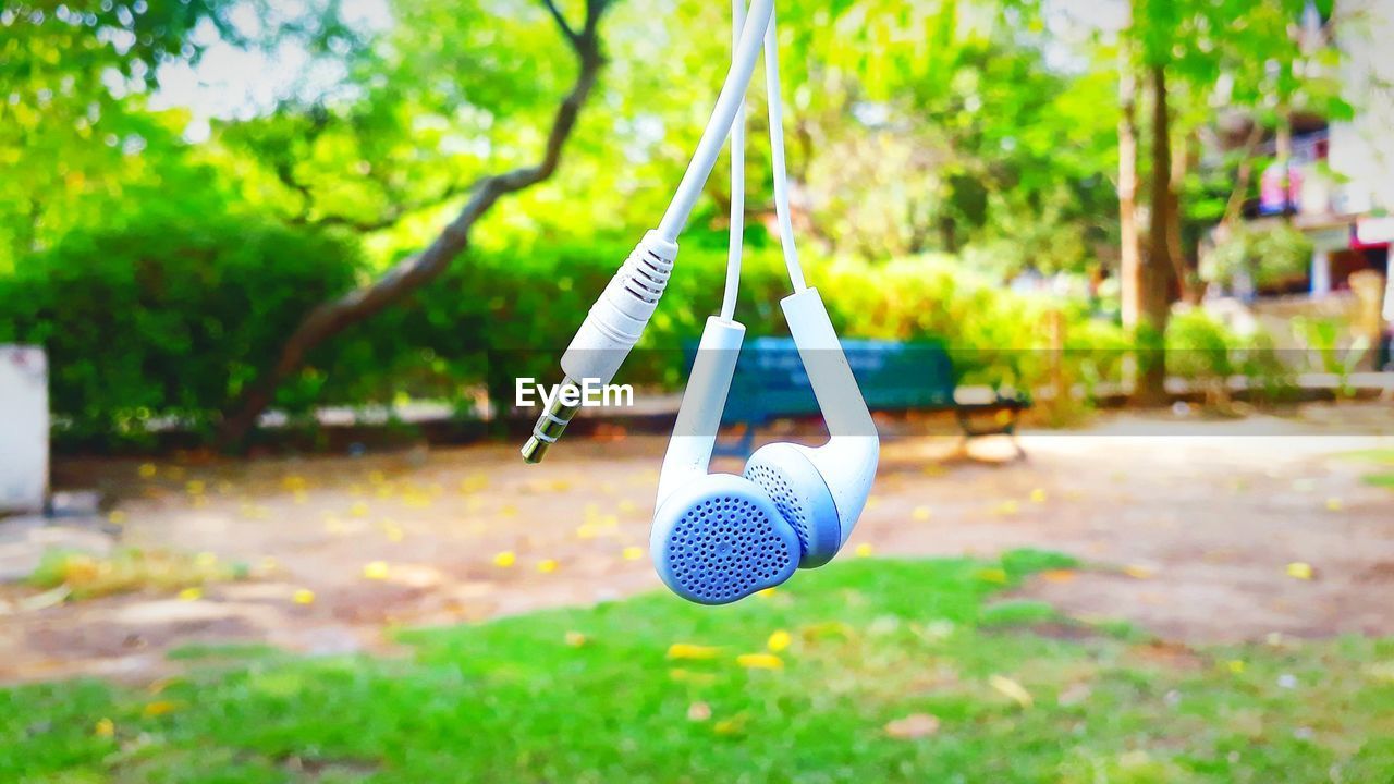 Close-up of earphone hanging in park