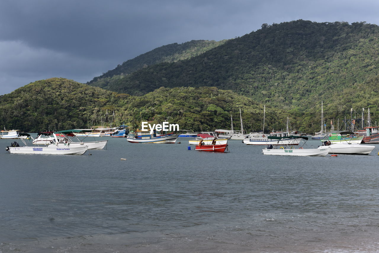 SCENIC VIEW OF SEA AGAINST MOUNTAINS