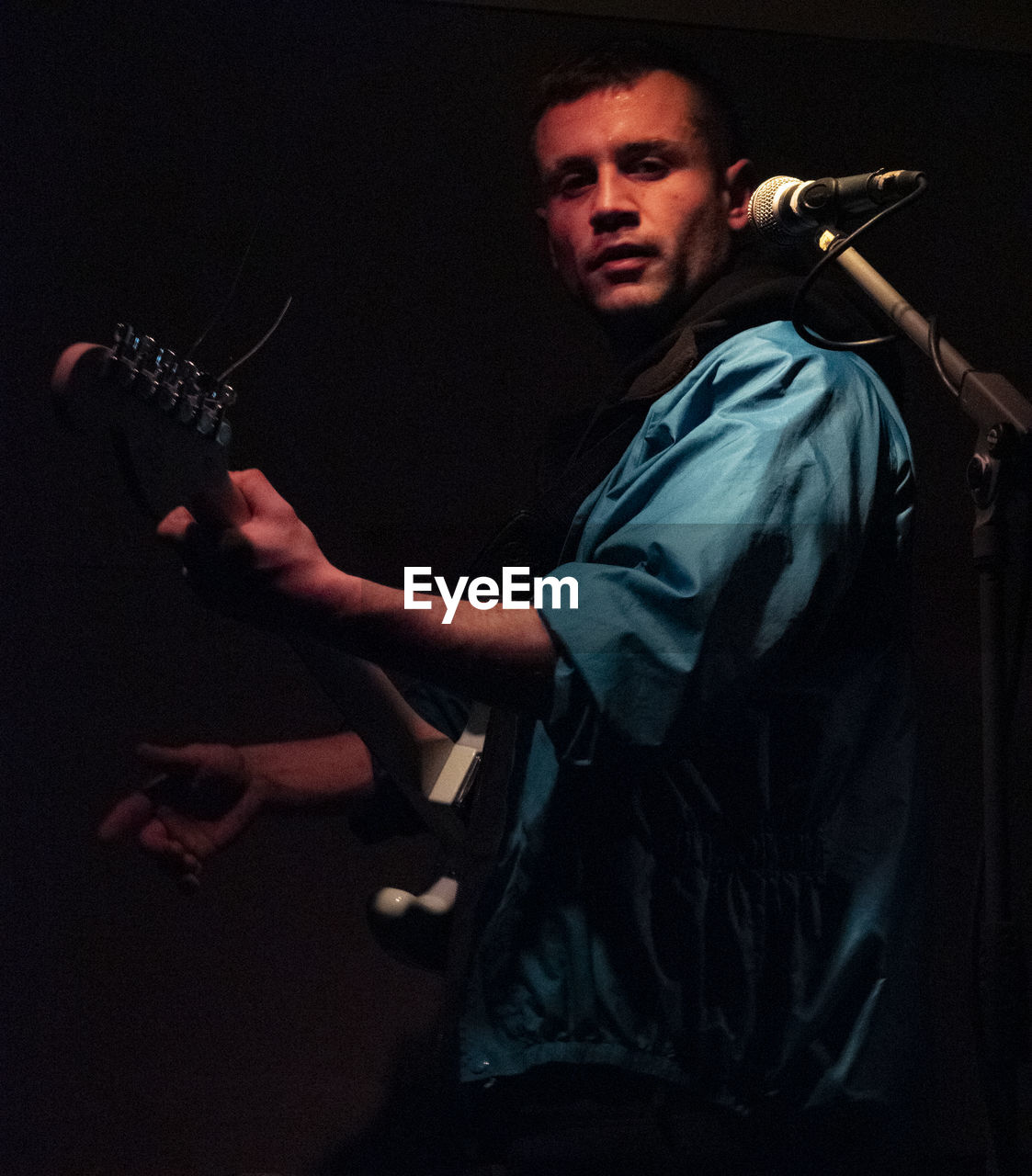 SIDE VIEW PORTRAIT OF YOUNG MAN PLAYING MUSIC CONCERT