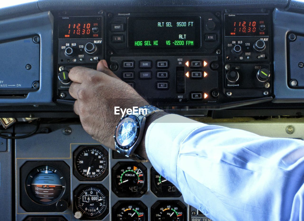 Cropped image of pilots operating cockpit