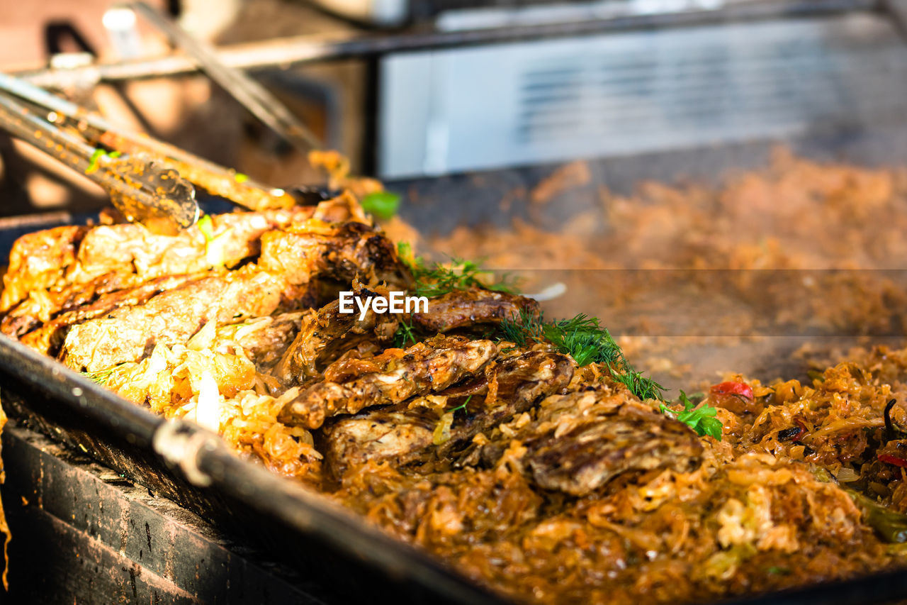 CLOSE-UP OF MEAT ON GRILL