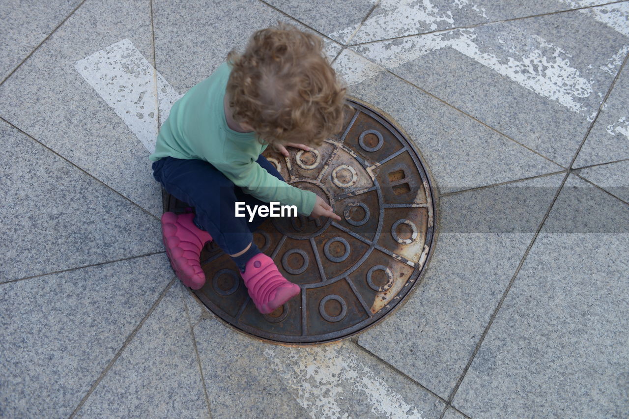 HIGH ANGLE VIEW OF CHILD ON FOOTPATH