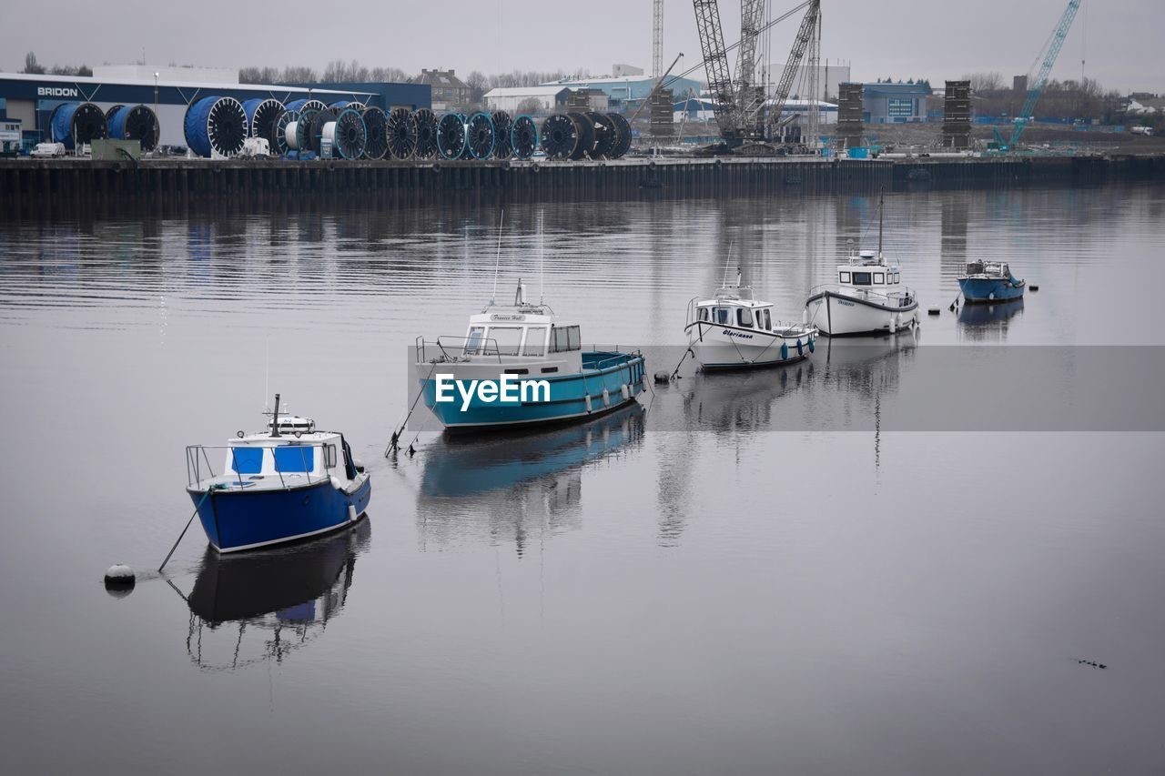 BOATS MOORED ON RIVER BY HARBOR