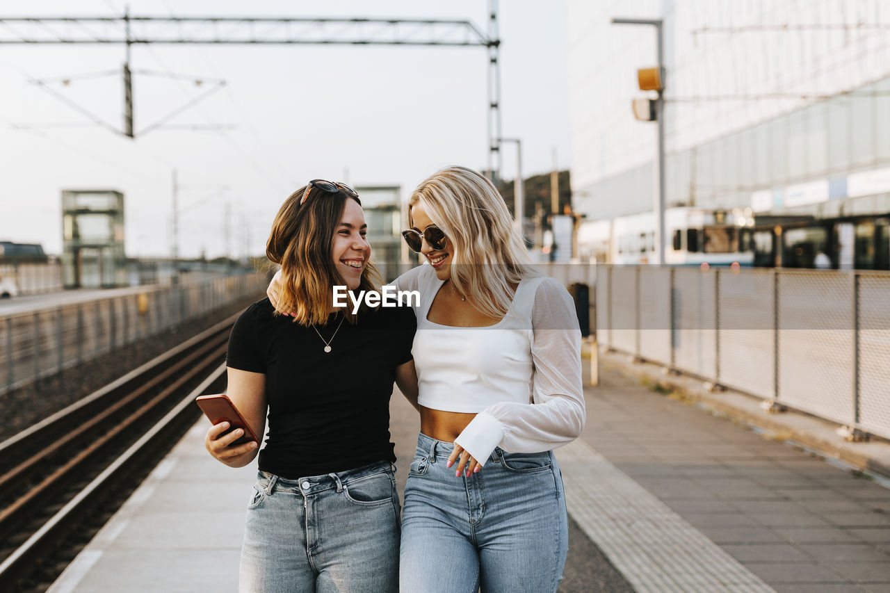 Smiling women at train station platform