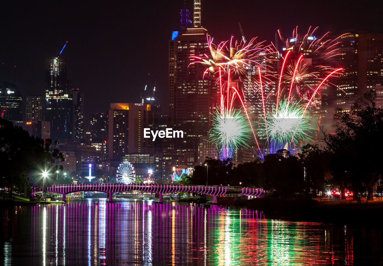 Firework display over yarra river and buildings at night