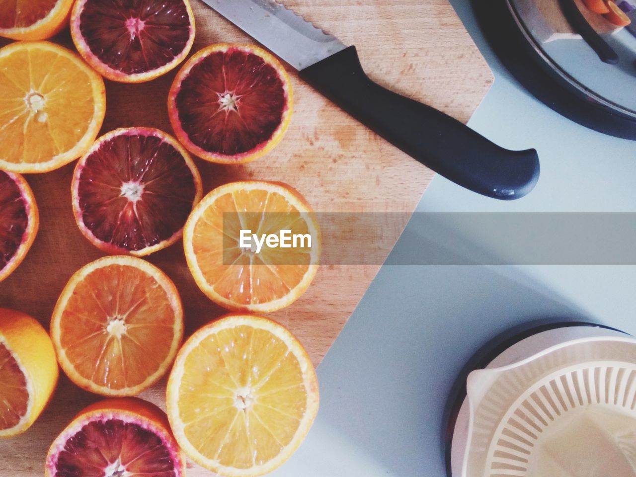 High angle view of halved grapefruits and oranges on cutting board