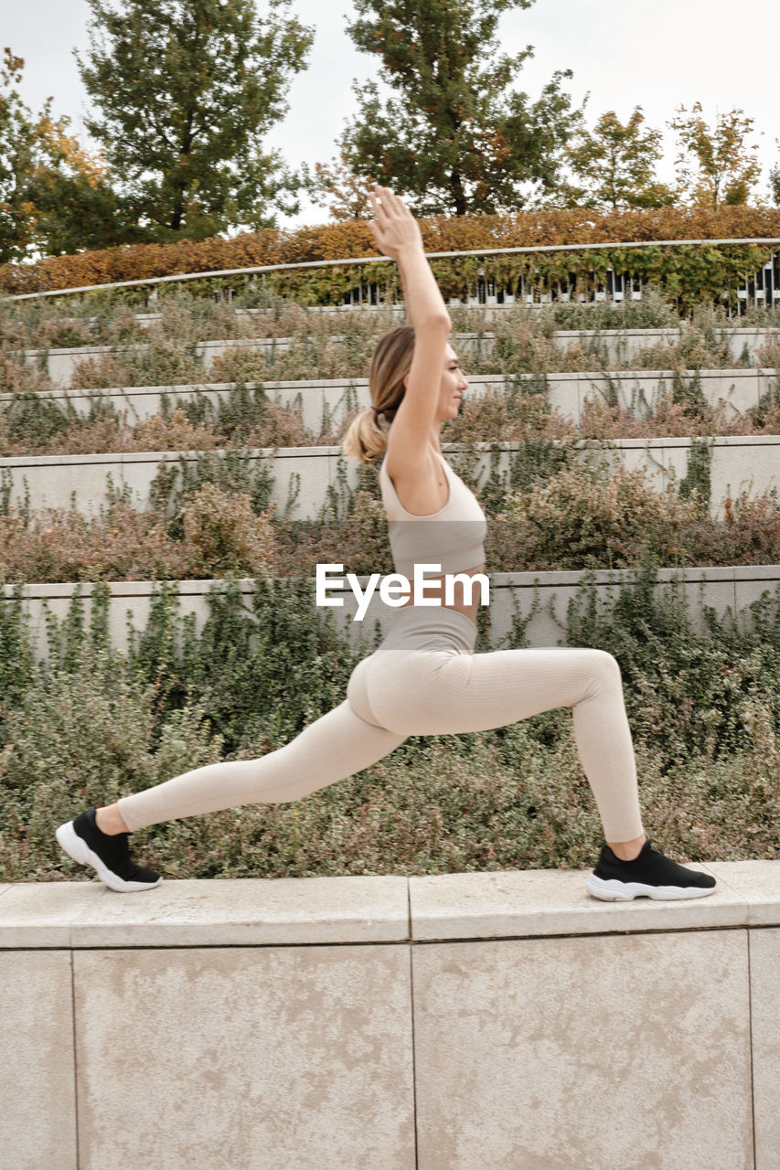 full length of young woman exercising on floor