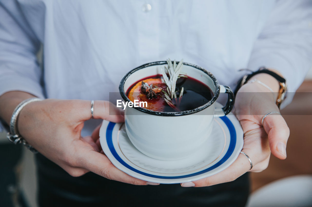 Midsection of person holding coffee