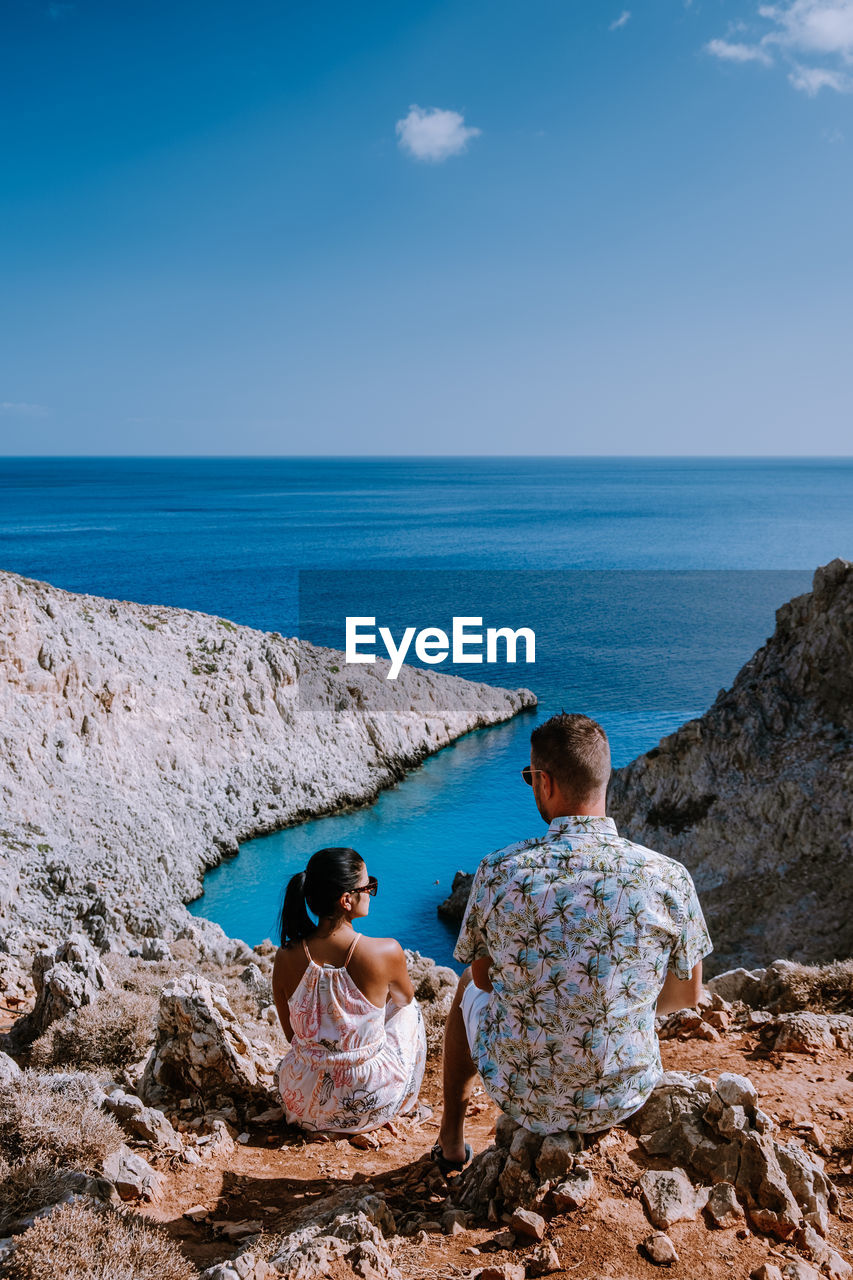 Rear view of couple looking at sea against sky