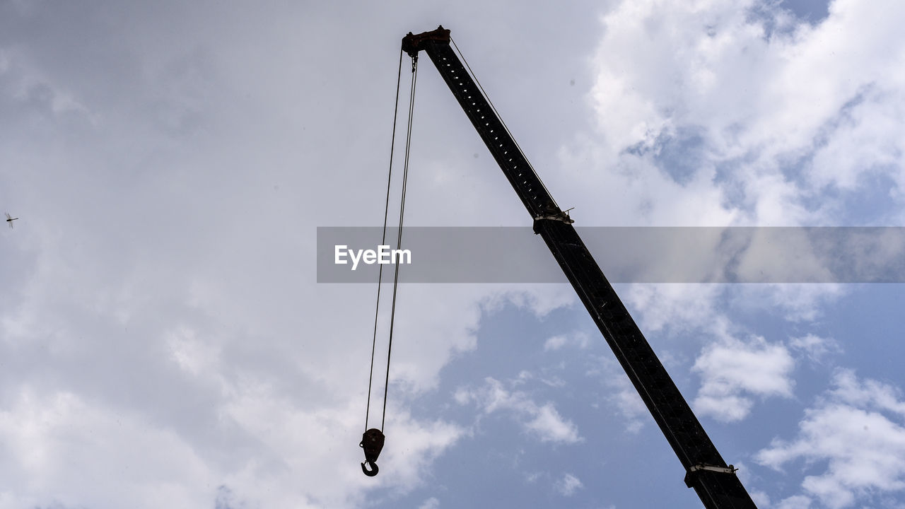 LOW ANGLE VIEW OF CRANES AT CONSTRUCTION SITE AGAINST SKY