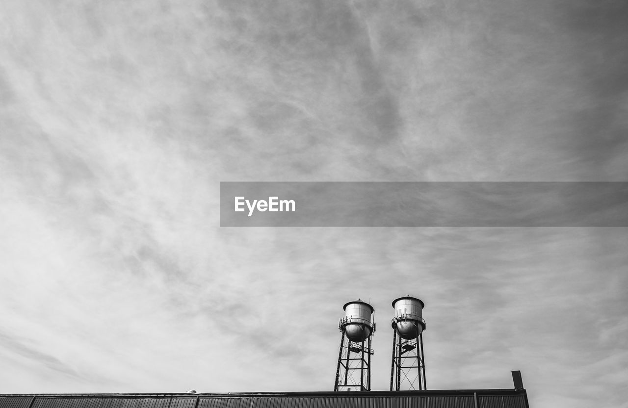 Low angle view of water tanks on building against sky