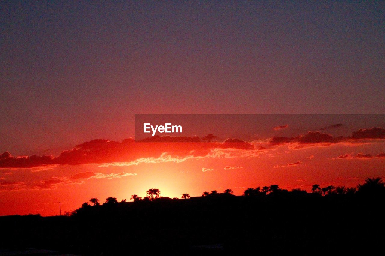 SCENIC VIEW OF SILHOUETTE LANDSCAPE AGAINST DRAMATIC SKY DURING SUNSET