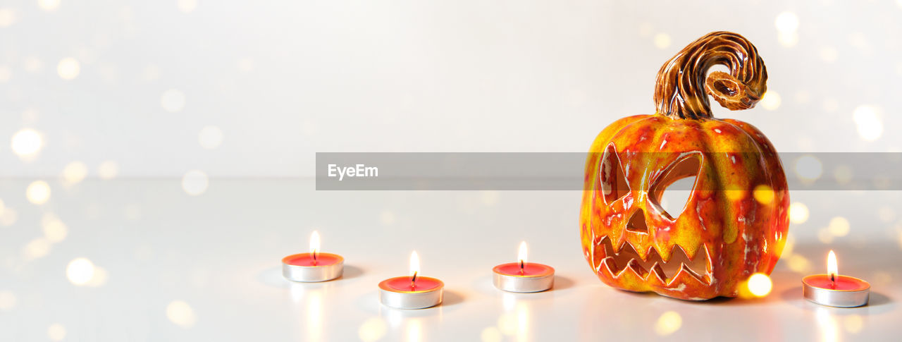 CLOSE-UP OF ILLUMINATED TEA LIGHT CANDLE