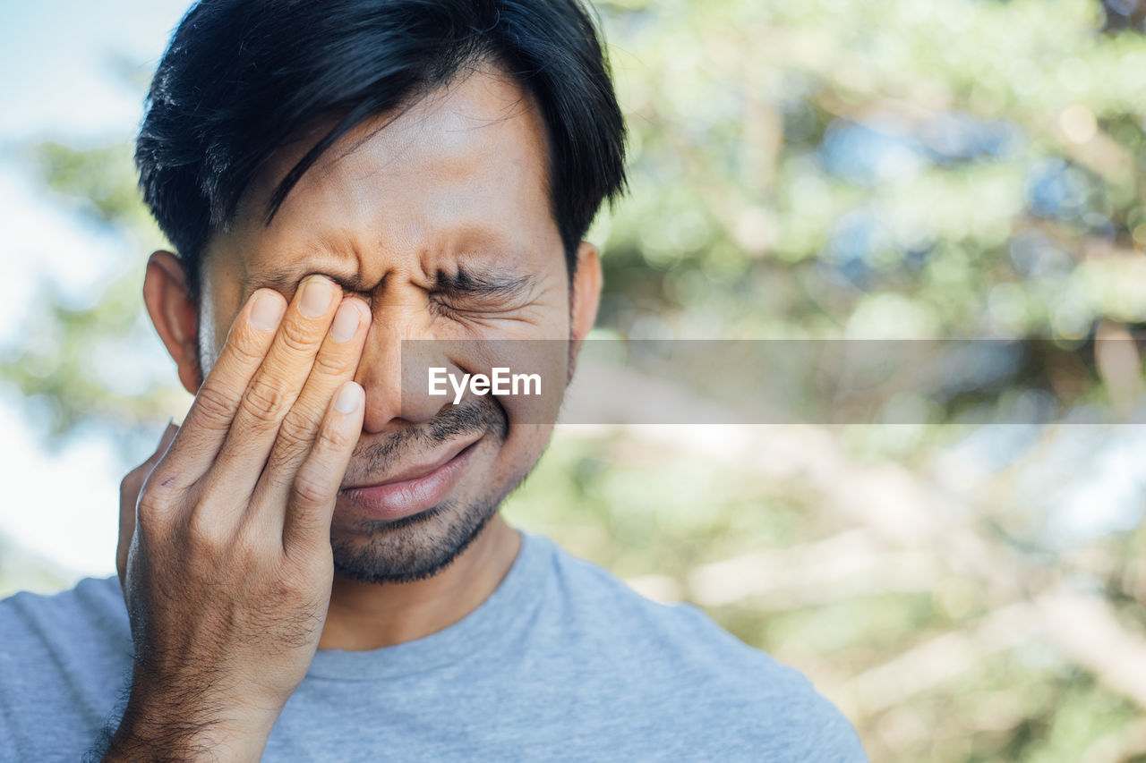 Close-up of man touching eye in pain