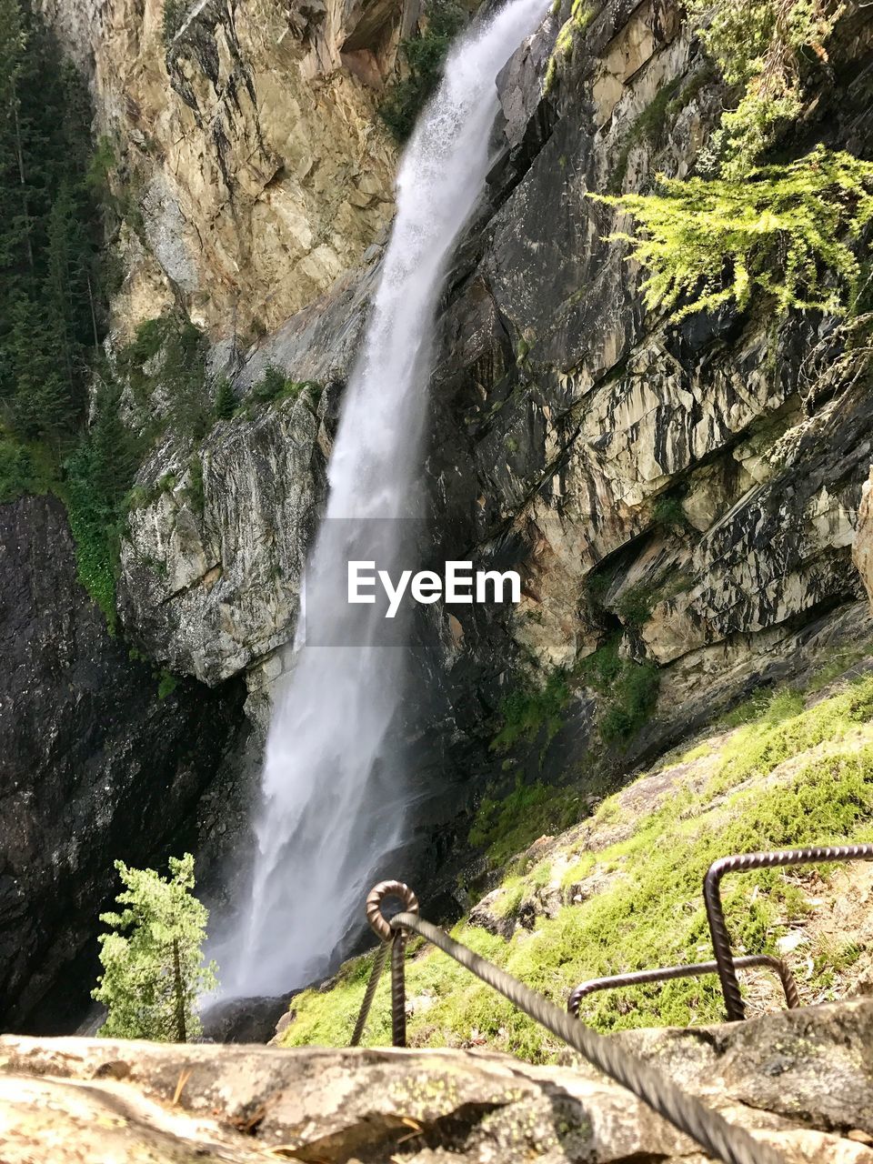 SCENIC VIEW OF WATERFALL AGAINST CLIFF