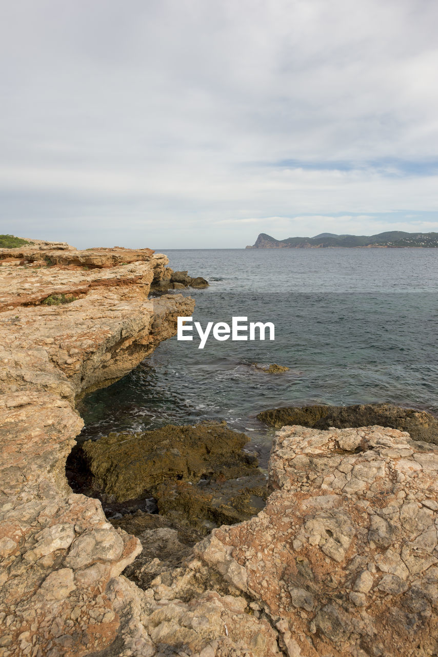 SCENIC VIEW OF ROCKS ON SEA AGAINST SKY