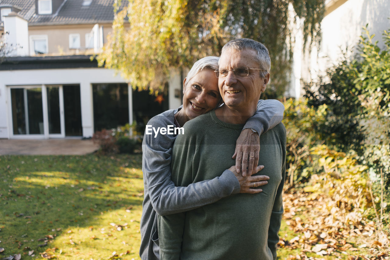 Happy affectionate senior couple hugging in garden