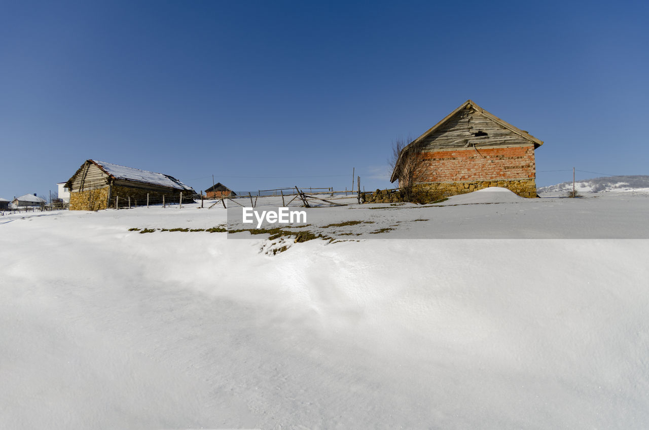 HOUSE ON SNOW AGAINST CLEAR SKY