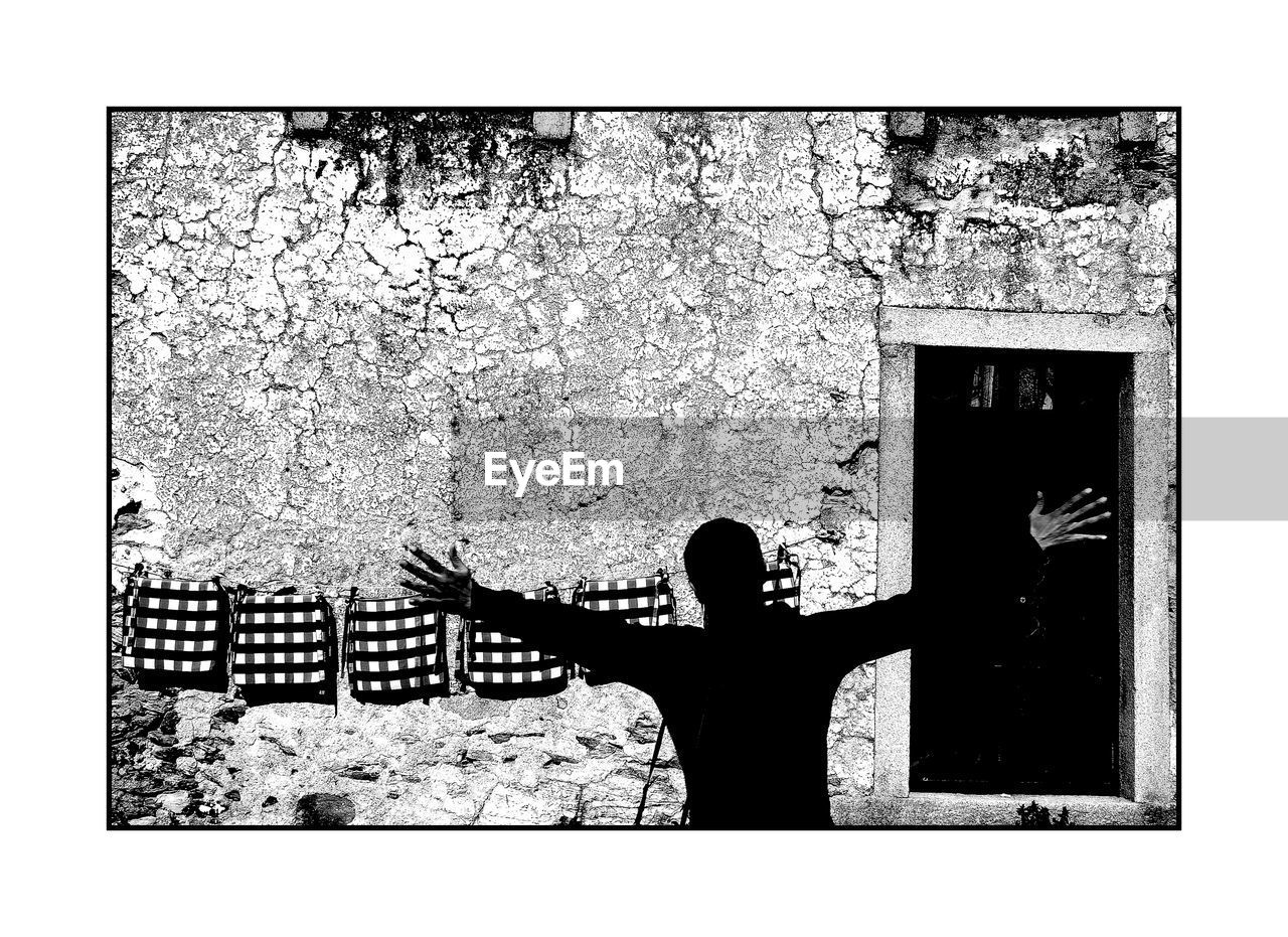 Rear view of man standing with arms outstretched