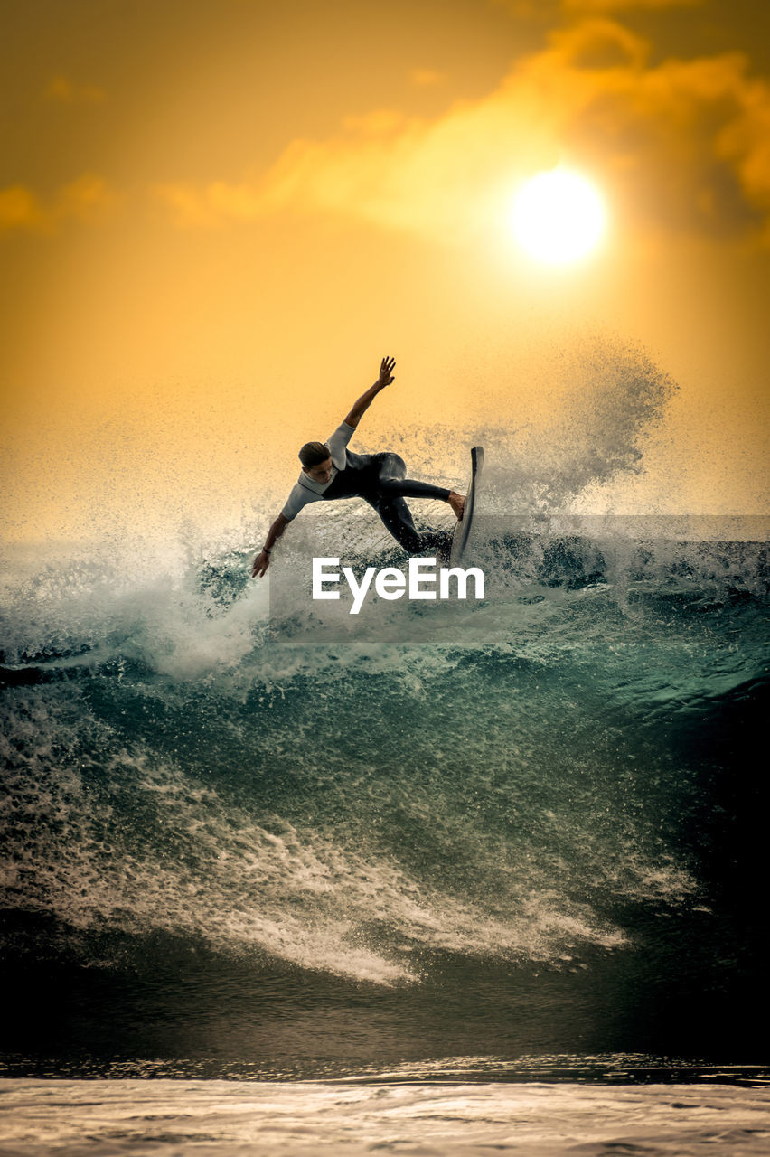 Young surfer with with wetsuit enjoying big waves in tenerife canary islands sporty boy riding surf 