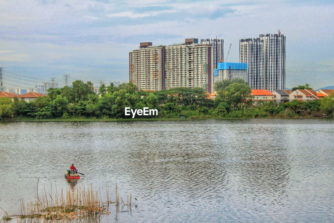 River by buildings against sky in city