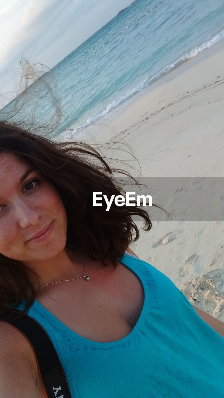 PORTRAIT OF YOUNG WOMAN IN BEACH