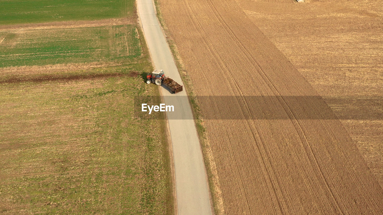 HIGH ANGLE VIEW OF MAN RIDING MOTORCYCLE ON ROAD