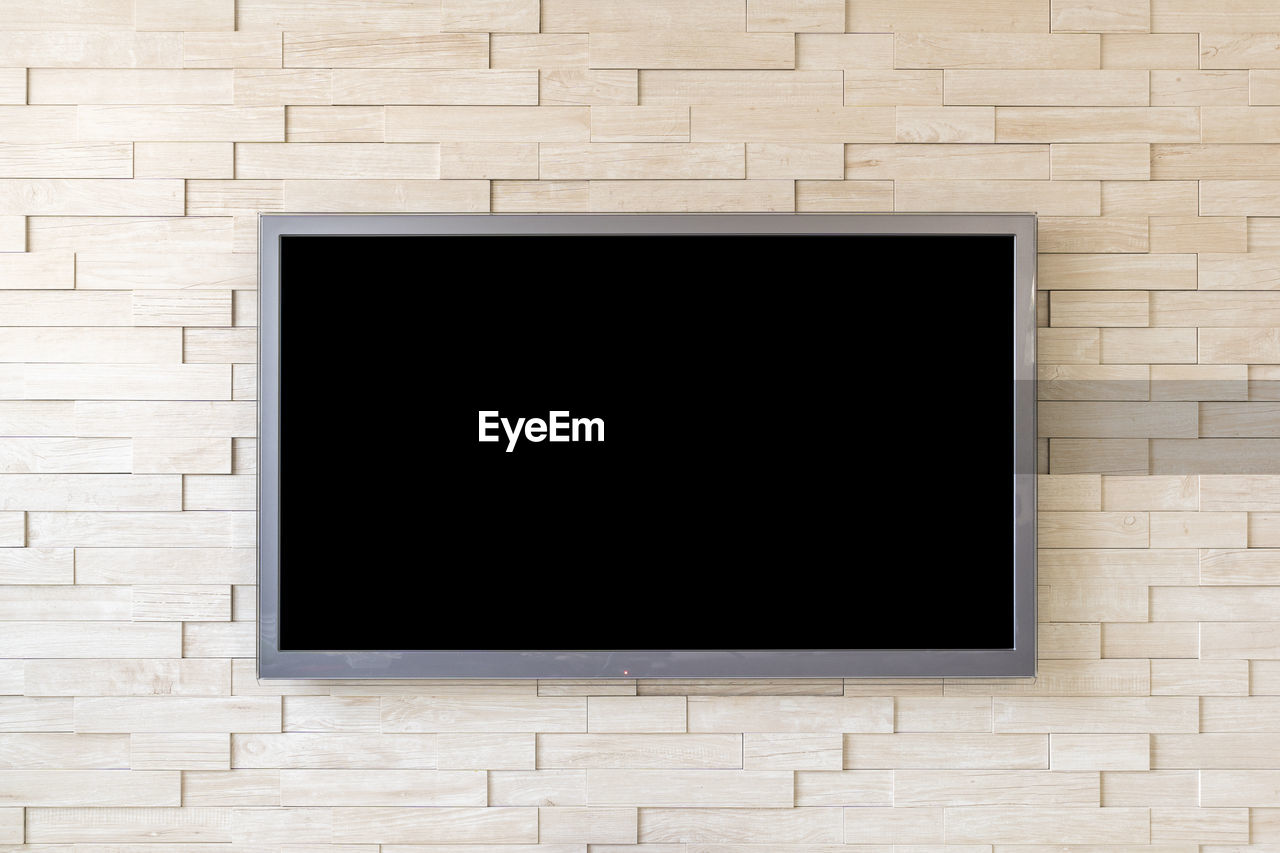 Blank television screen on wall at home