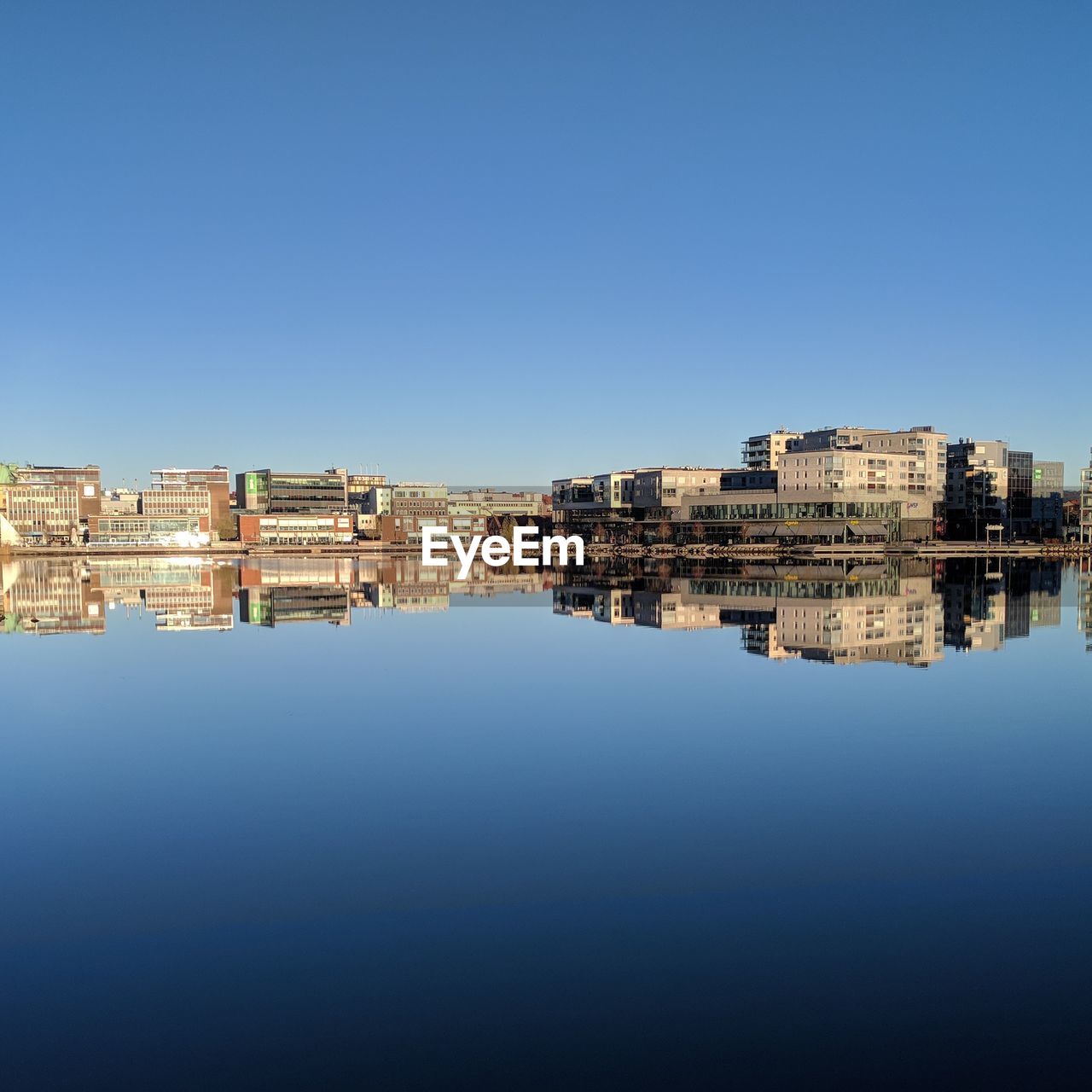 Buildings in city against clear blue sky